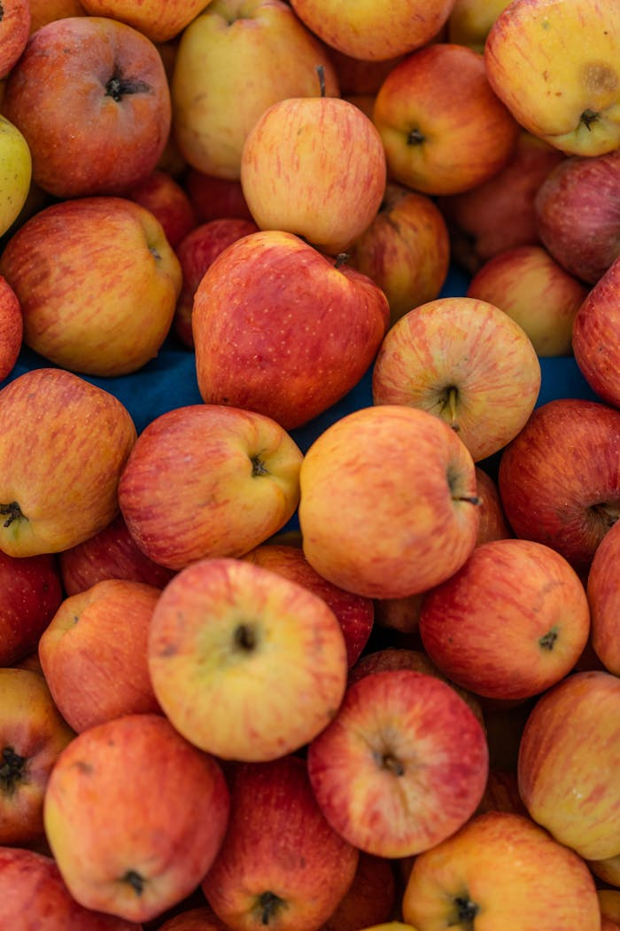 Vertical close-up of fresh apples in vivid colors, highlighting natural texture and freshness.